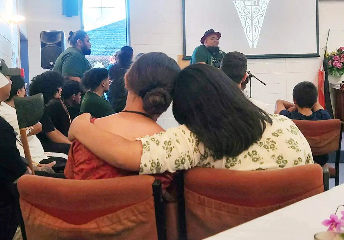 Two people sitting next to each other, one with their arm around the other